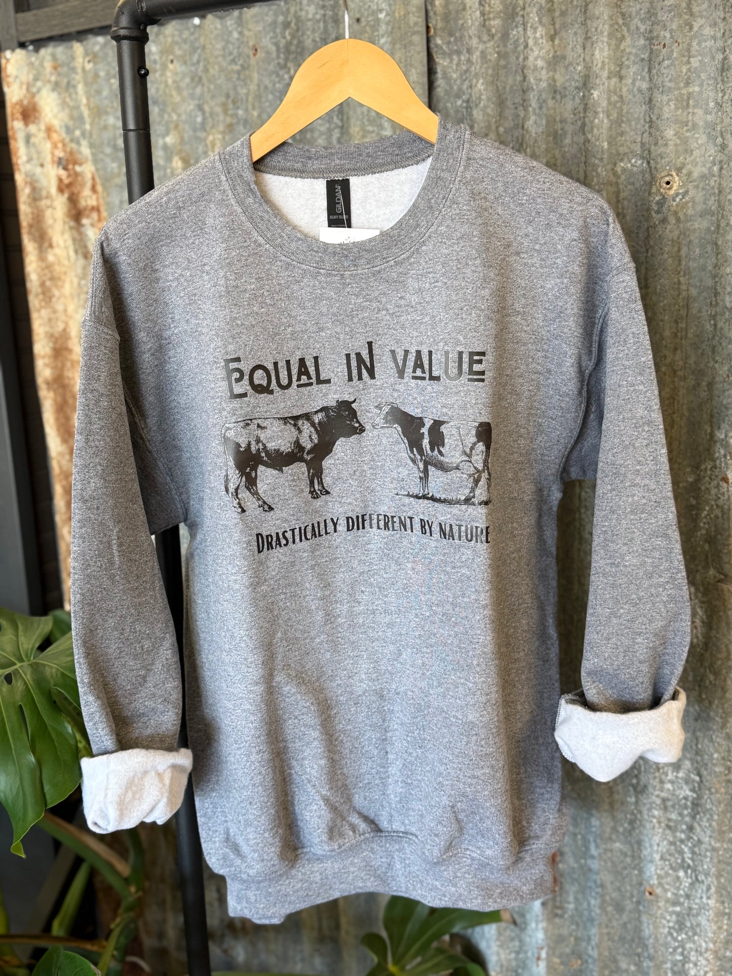 Gray sweatshirt with cow graphic and text Equal in Value Drastically Different by Nature - Birkland Boutique