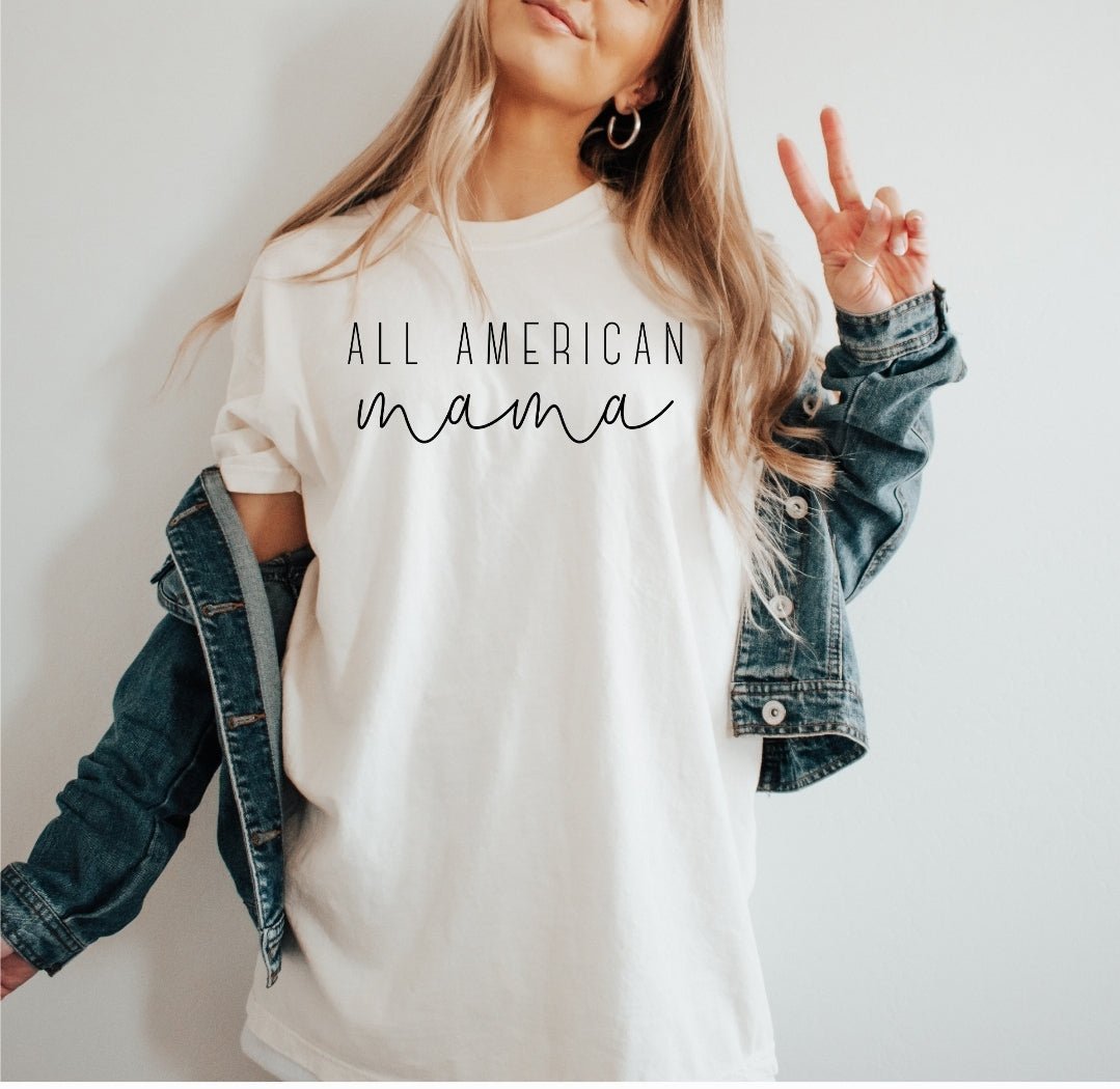 Woman wearing white All American Mama patriotic graphic tee with denim jacket from Faith & Freedom boutique collection