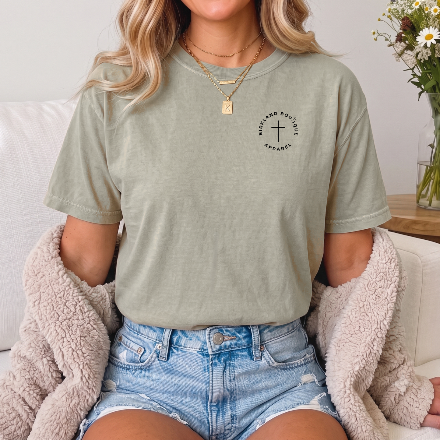 Front of sand-colored Christian graphic tee featuring a minimalist cross logo on the left chest.