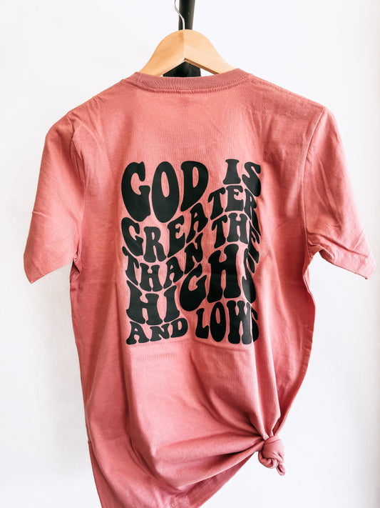 Blush Christian faith tee hanging on hanger with back showing design says God is Greater than our Highs and Lows
