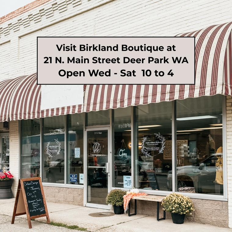 Birkland Boutique storefront with striped awning and sidewalk sign.